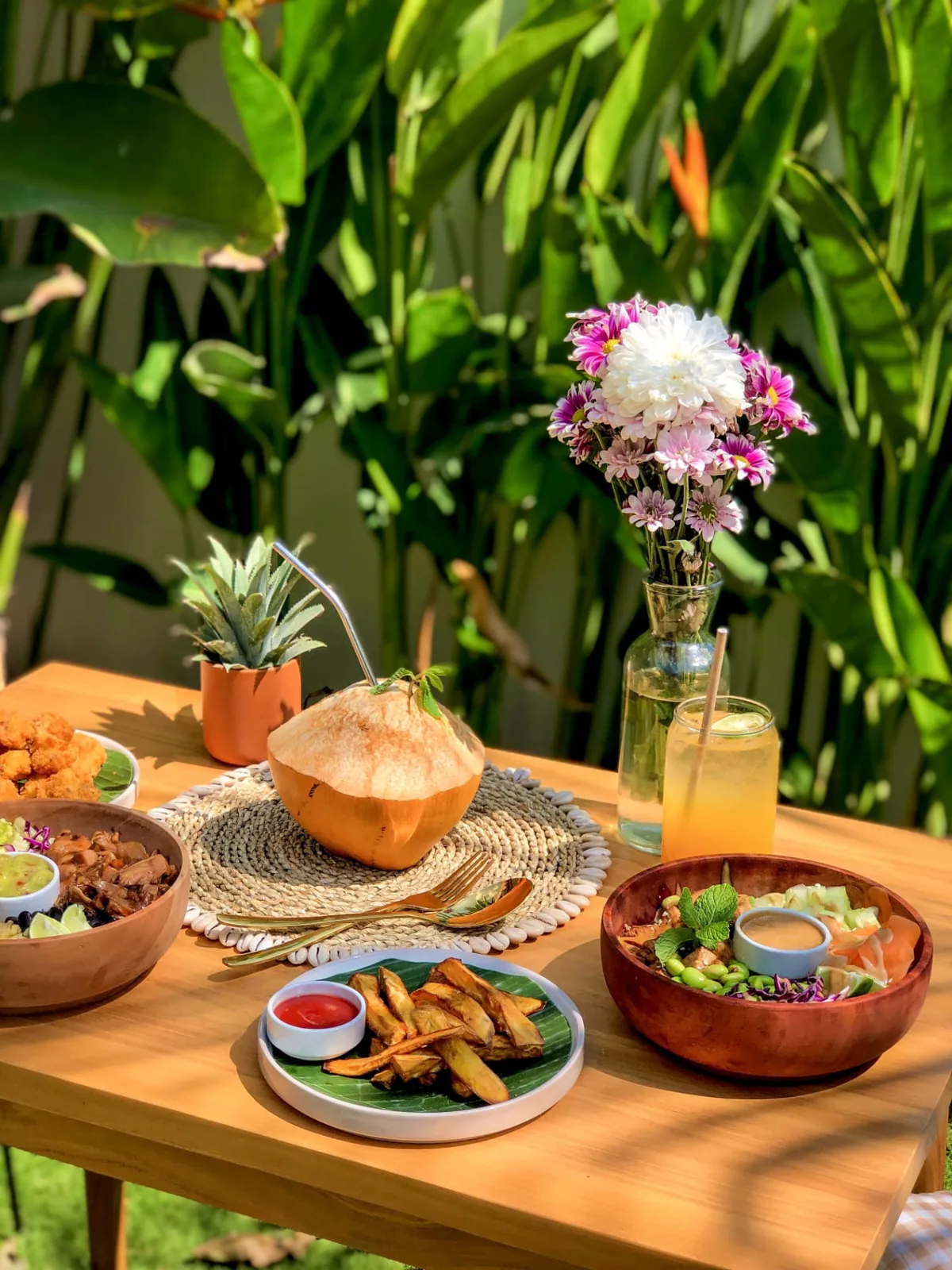 Cassava fries, bowls and a cold drink on a table at Luana Bowls in Selong Belanak