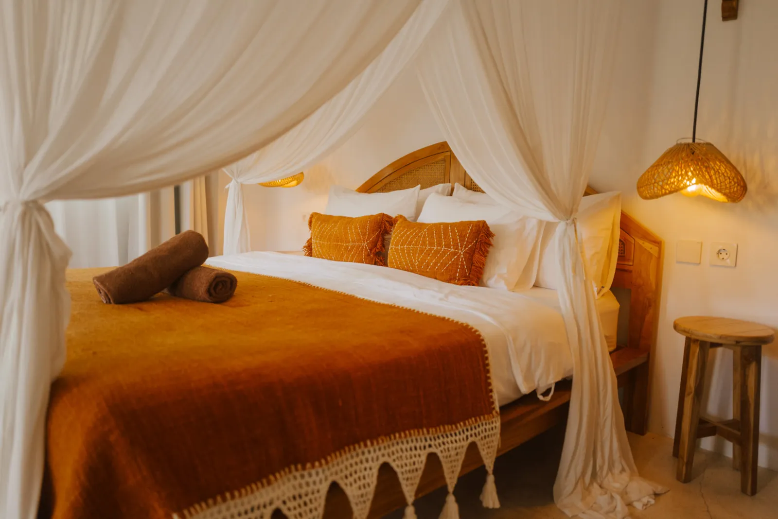 Warm evening light over the bed in the Private Bungalow